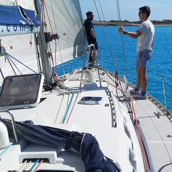 2 personas en velero atracado preparándolo para salir