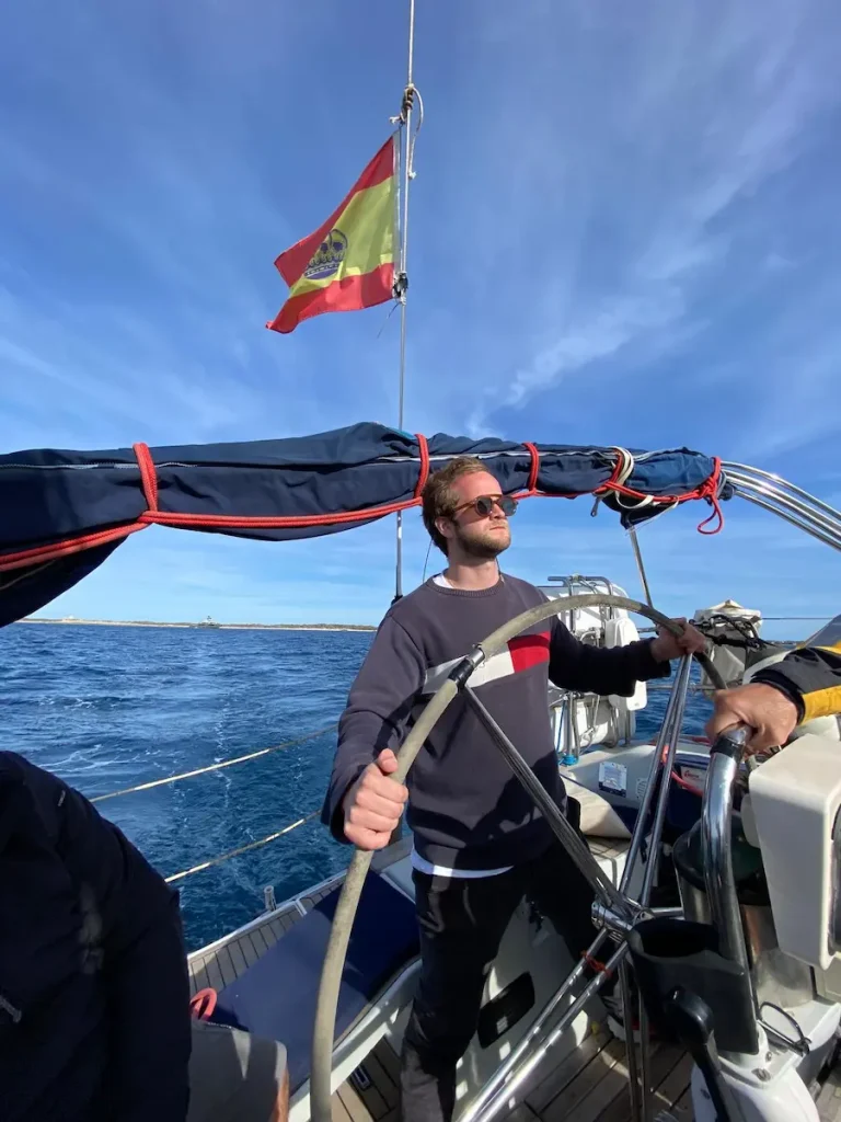 navegante en prácticas náuticas manejando un velero